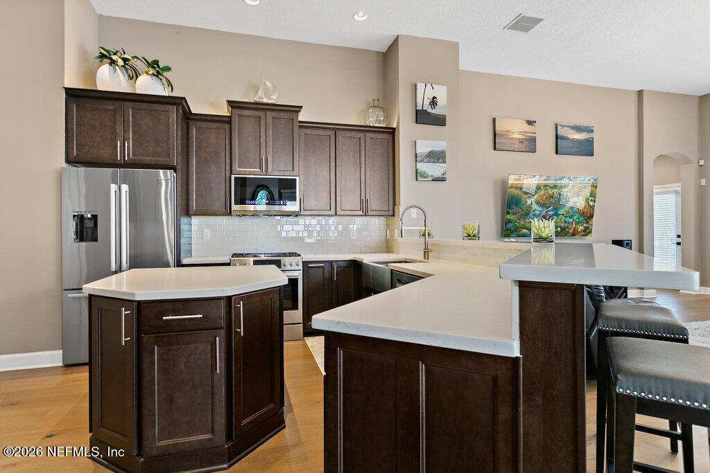 841 Ifield Road St. Augustine, FL 32095 - Photo 12 of 69 a kitchen with stainless steel appliances a sink a stove a refrigerator cabinets and a dining table