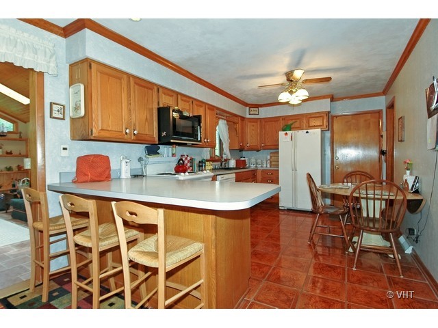 11N918 Almora Terrace Elgin, IL 60124 - Photo 3 of 10 a kitchen with a table chairs refrigerator and microwave