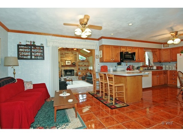 11N918 Almora Terrace Elgin, IL 60124 - Photo 4 of 10 a living room with kitchen island furniture a chandelier and kitchen view