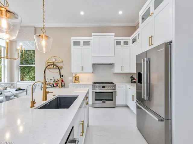 a kitchen with refrigerator a sink and white cabinets