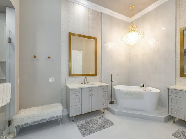 a bathroom with a double vanity sink mirror and bathtub