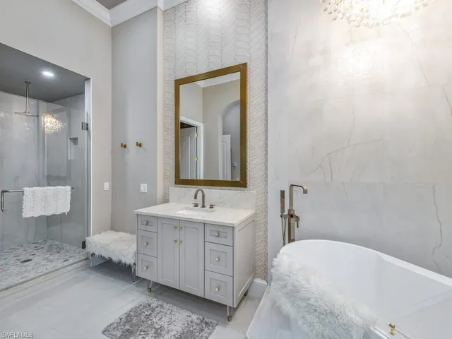 a en suite bathroom with a double vanity sink a mirror and a bathtub