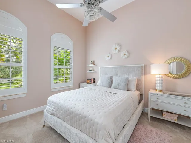 a bedroom with a bed chandelier and a window
