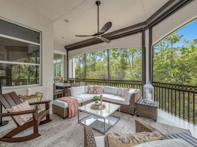 a living room with furniture and floor to ceiling windows