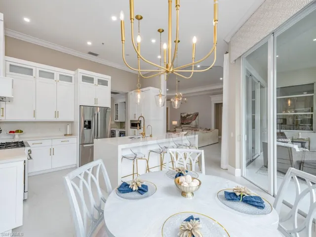 a large kitchen with stainless steel appliances kitchen island granite countertop a table and chairs