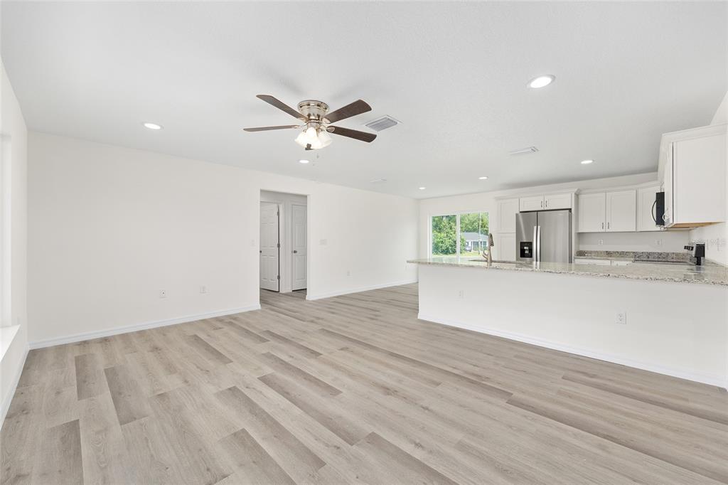 13019 Northeast 7th Loop Silver Springs, FL 34488 - Photo 12 of 35 a view of a kitchen with an empty space and a ceiling fan