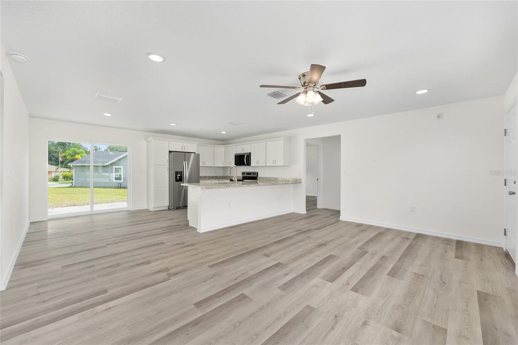 13019 Northeast 7th Loop Silver Springs, FL 34488 - Photo 15 of 35 a view of a kitchen with wooden floor and a ceiling fan