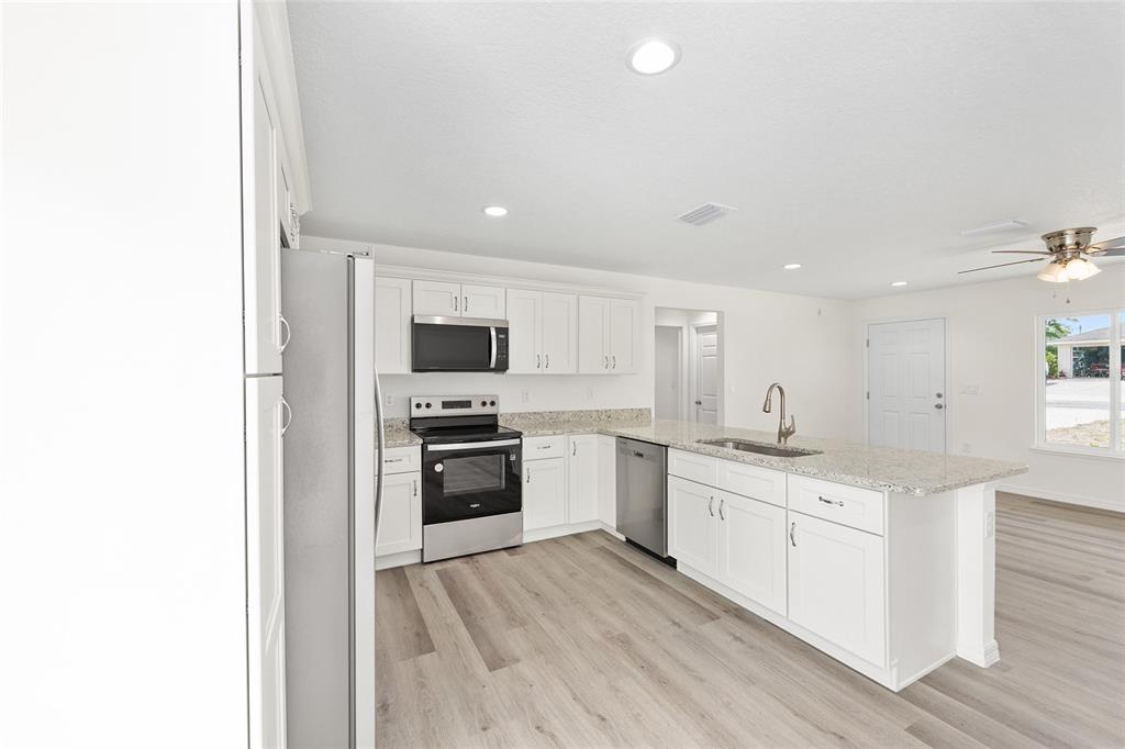 13019 Northeast 7th Loop Silver Springs, FL 34488 - Photo 19 of 35 a kitchen with stainless steel appliances a sink stove and refrigerator