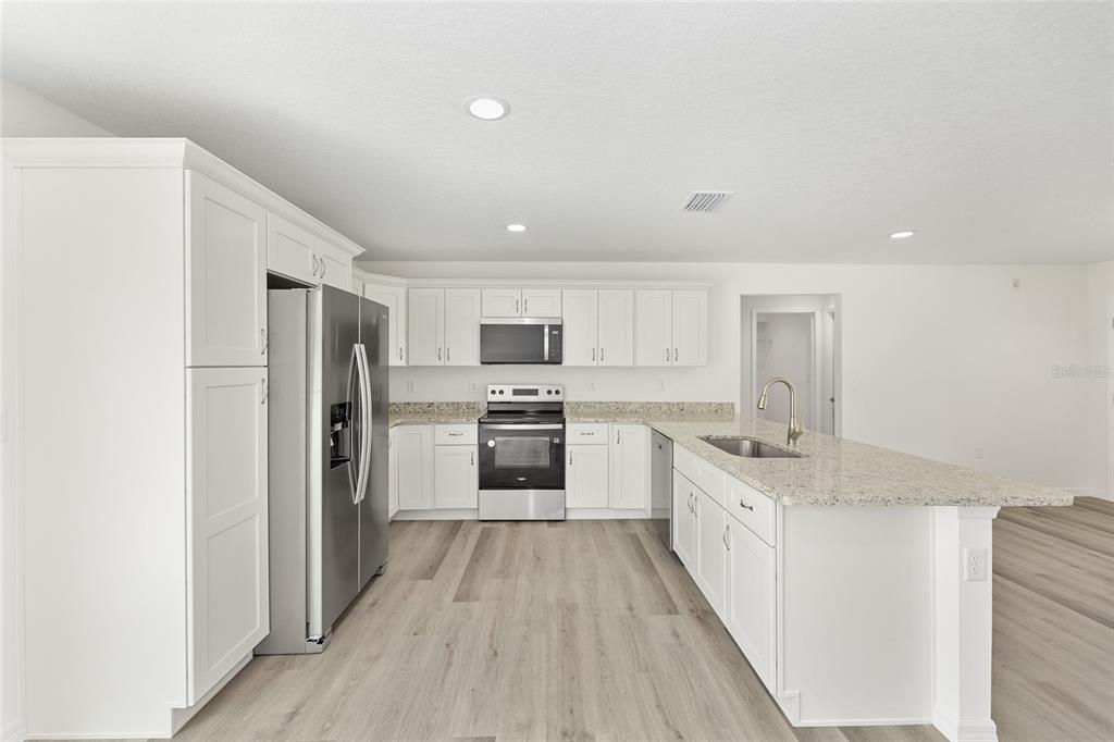 13019 Northeast 7th Loop Silver Springs, FL 34488 - Photo 20 of 35 a kitchen with stainless steel appliances a refrigerator sink and stove