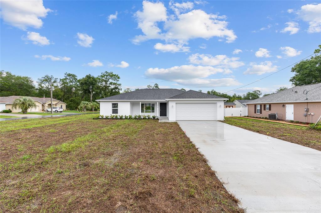 13019 Northeast 7th Loop Silver Springs, FL 34488 - Photo 4 of 35 a front view of a house with garden