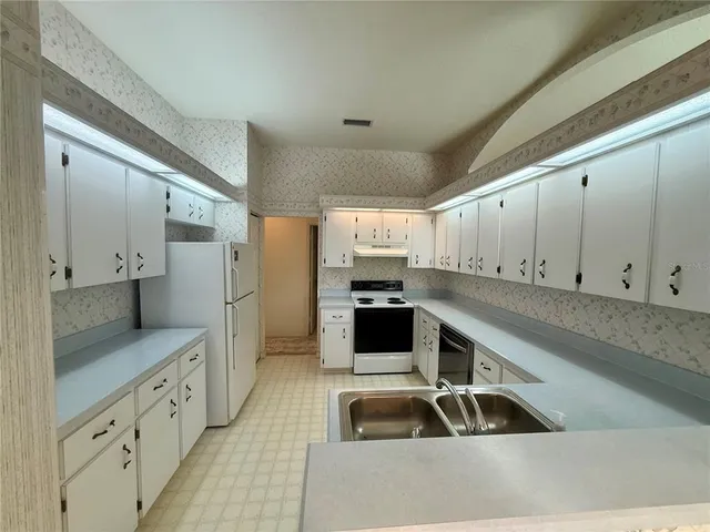 a kitchen with stainless steel appliances a sink a stove and a refrigerator