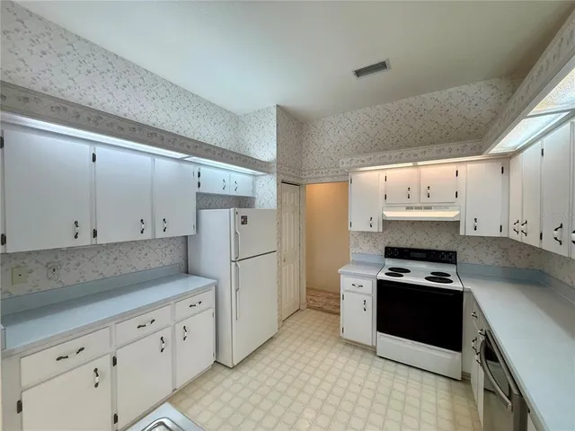 a kitchen with granite countertop cabinets and refrigerator