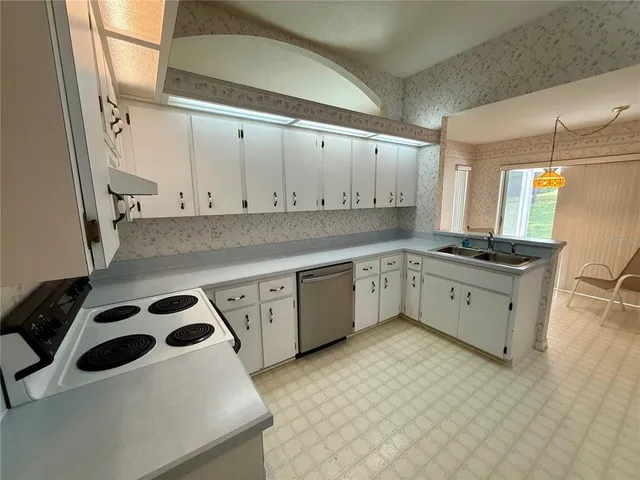 a kitchen with stainless steel appliances a stove a sink and a refrigerator