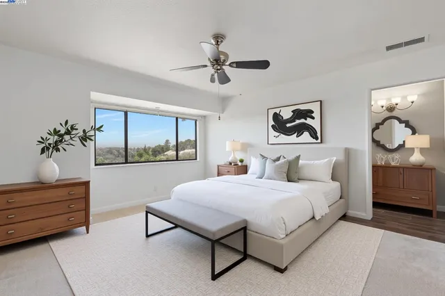 a spacious bedroom with a bed couch and window