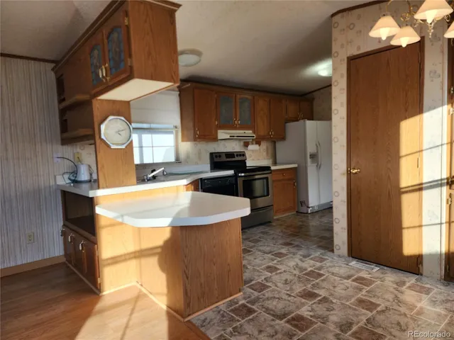 a kitchen with refrigerator cabinets and window