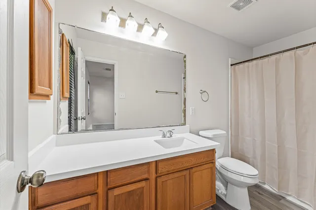 a bathroom with a sink vanity mirror and toilet