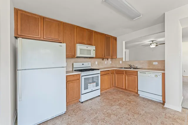 a kitchen with a refrigerator sink stove microwave and cabinets