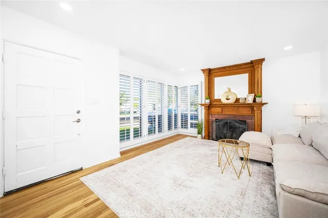 a living room with furniture a fireplace and a floor to ceiling window