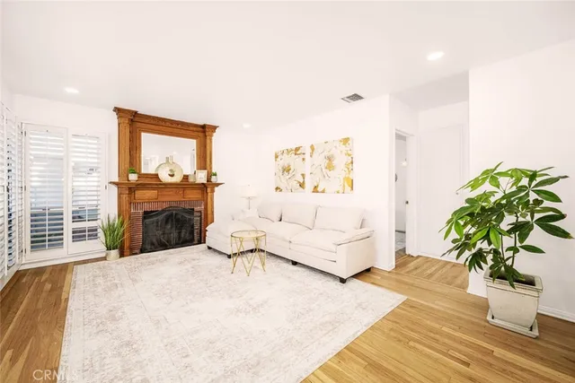 a living room with furniture a fireplace and a potted plant