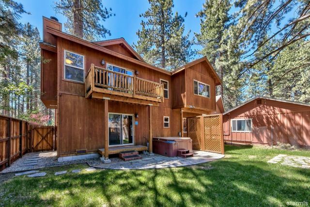 a view of an house with backyard and wooden fence