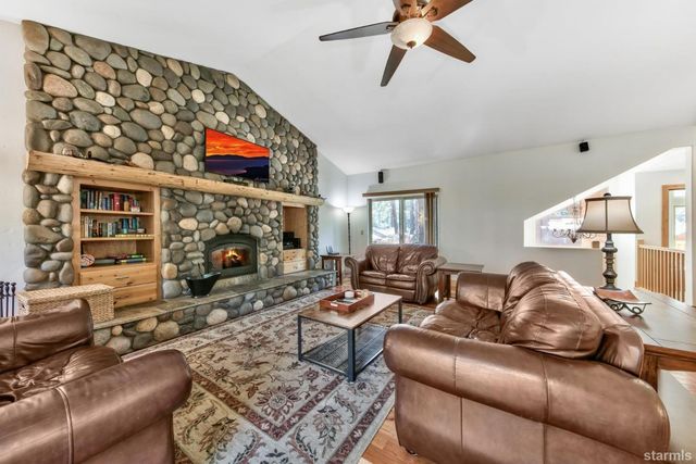 a living room with furniture a flat screen tv and a fireplace