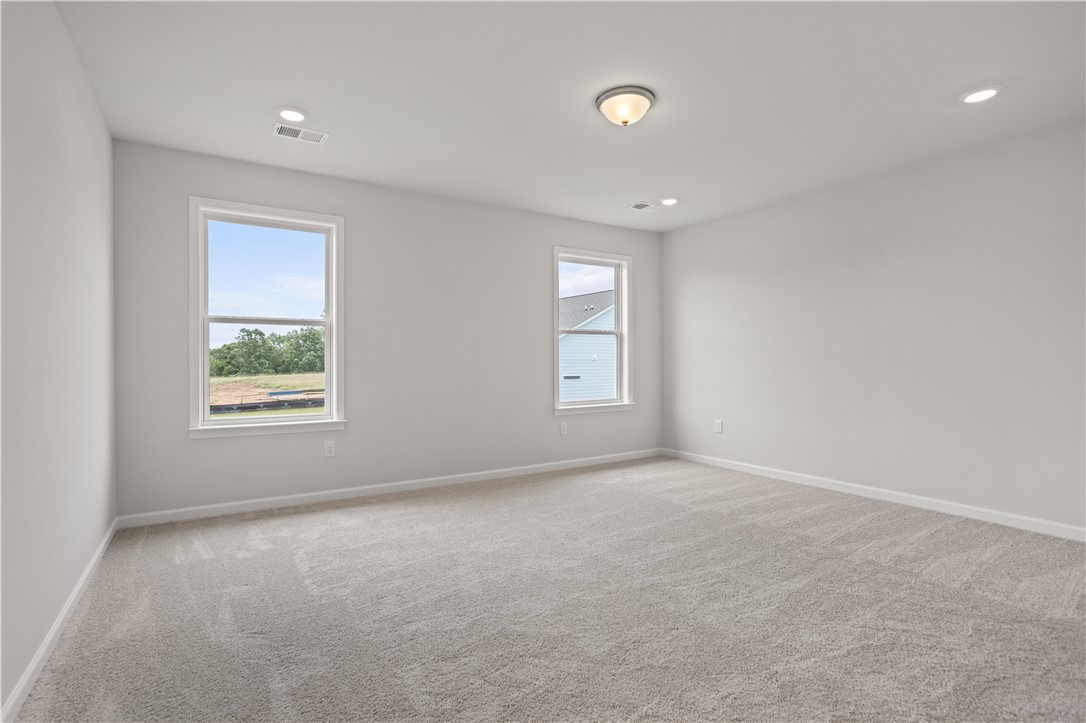 555 Hydrangea Street, Unit LOT 47 Seneca, SC 29678 - Photo 22 of 38 A spacious room offers comfortable carpeting, ample natural light, and modern recessed lighting.
