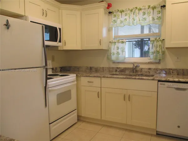 a kitchen with stainless steel appliances granite countertop cabinets and a refrigerator