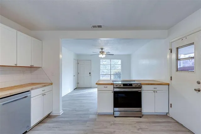 a kitchen with stainless steel appliances a stove a sink and a microwave