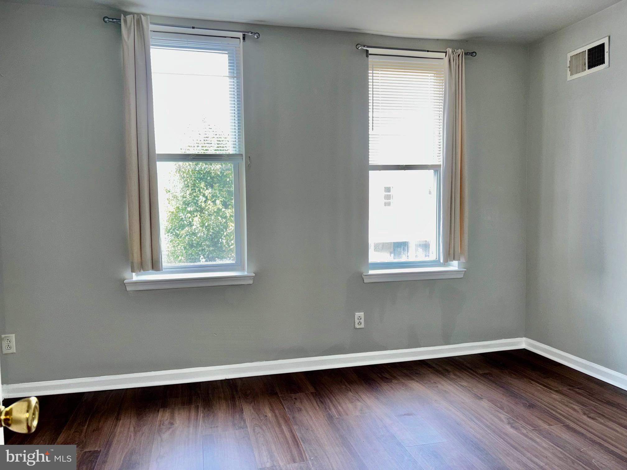 5258 Hazel Avenue Philadelphia, PA 19143 - Photo 19 of 22 an empty room with wooden floor and windows