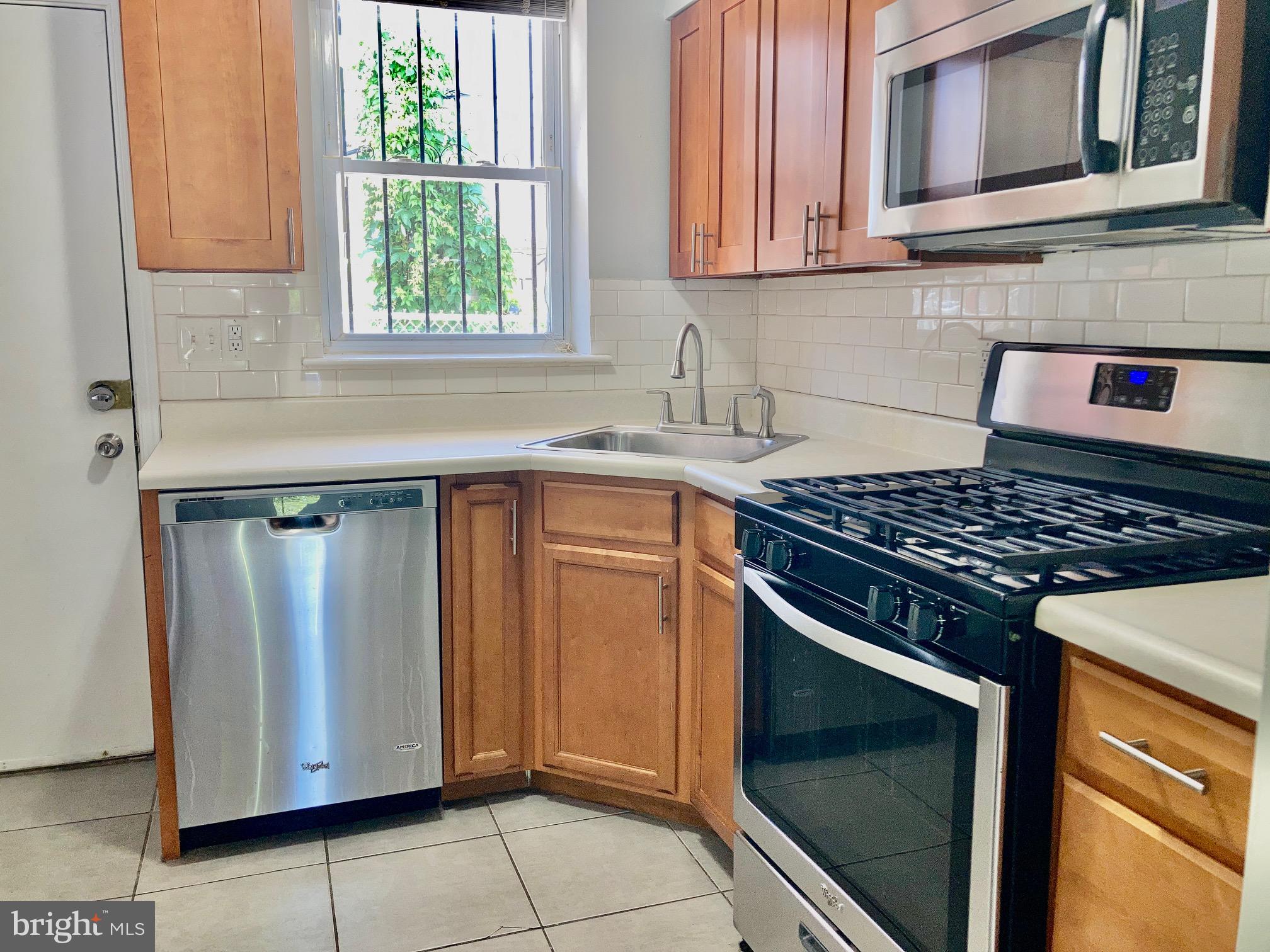5258 Hazel Avenue Philadelphia, PA 19143 - Photo 4 of 22 a kitchen with stainless steel appliances granite countertop a stove and a microwave