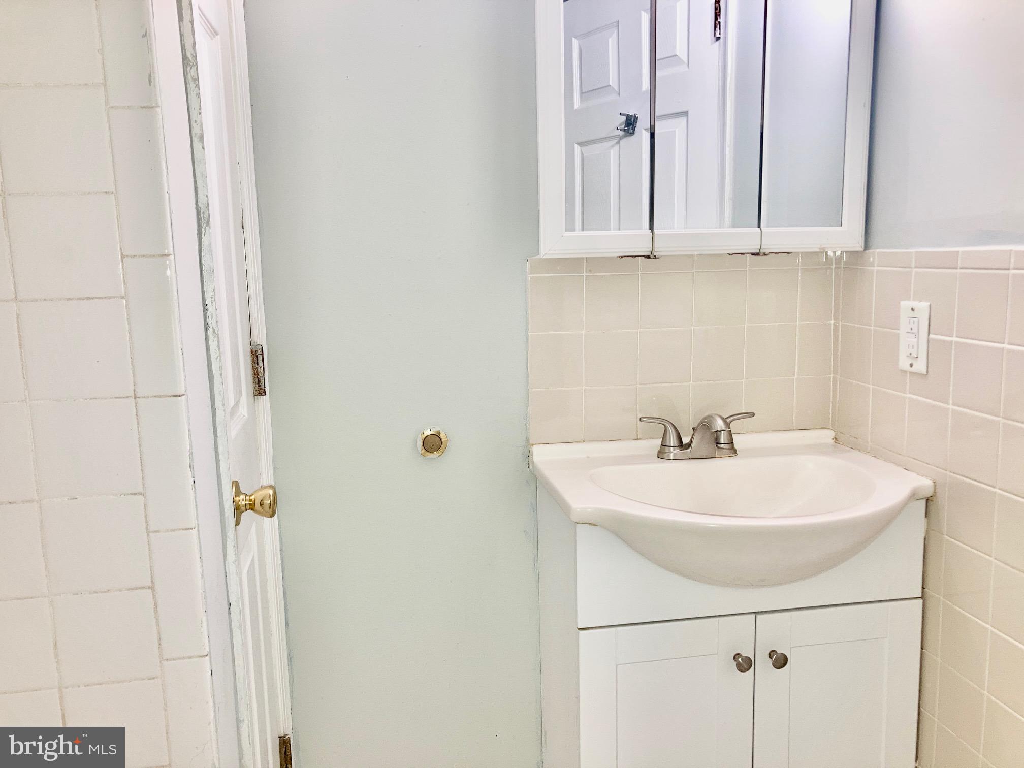 5258 Hazel Avenue Philadelphia, PA 19143 - Photo 10 of 22 a bathroom with a sink and a mirror