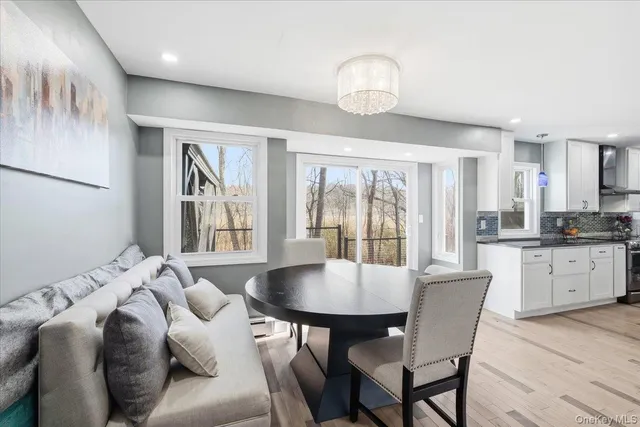 a kitchen with stainless steel appliances kitchen island granite countertop a stove a sink a refrigerator with a dining table and chairs