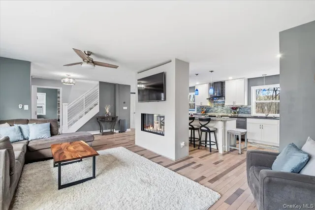 a living room with furniture kitchen view and a wooden floor