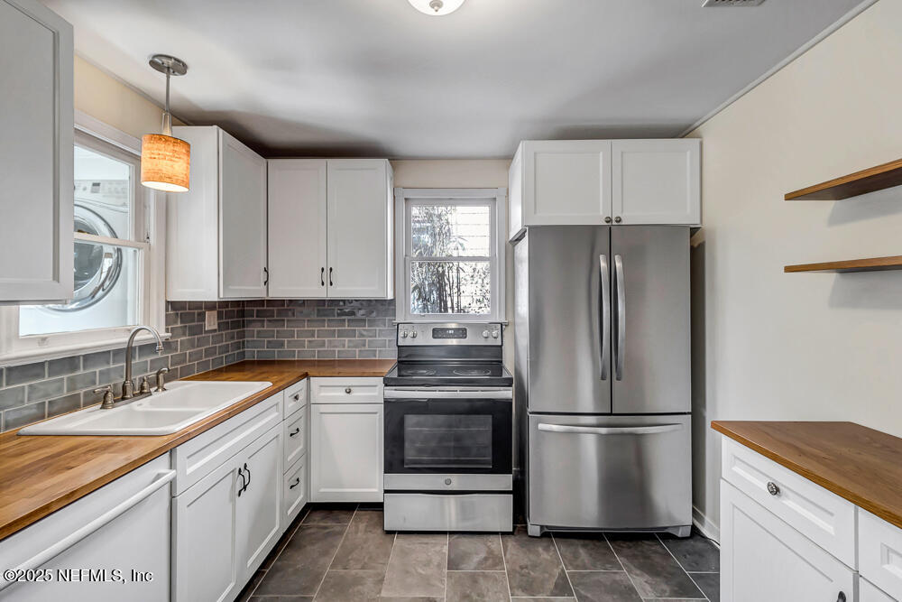 60 Weeden Street St. Augustine, FL 32084 - Photo 9 of 46 a kitchen with a refrigerator sink and cabinets