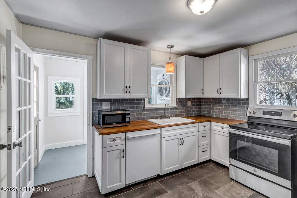 60 Weeden Street St. Augustine, FL 32084 - Photo 10 of 46 a kitchen with white cabinets and white appliances