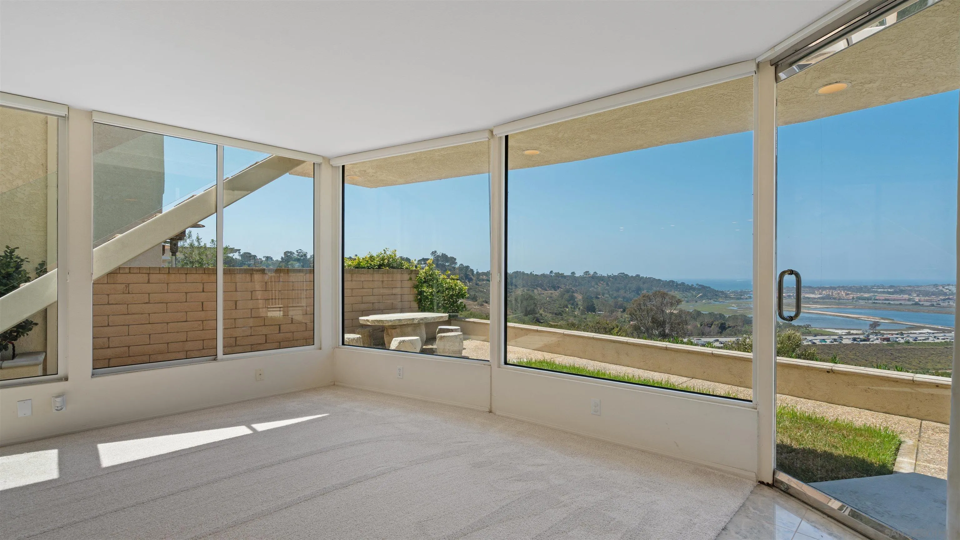 13286 Ocean Vista Road San Diego, CA 92130 - Photo 24 of 66 a view of an empty room with wooden floor and iron stairs