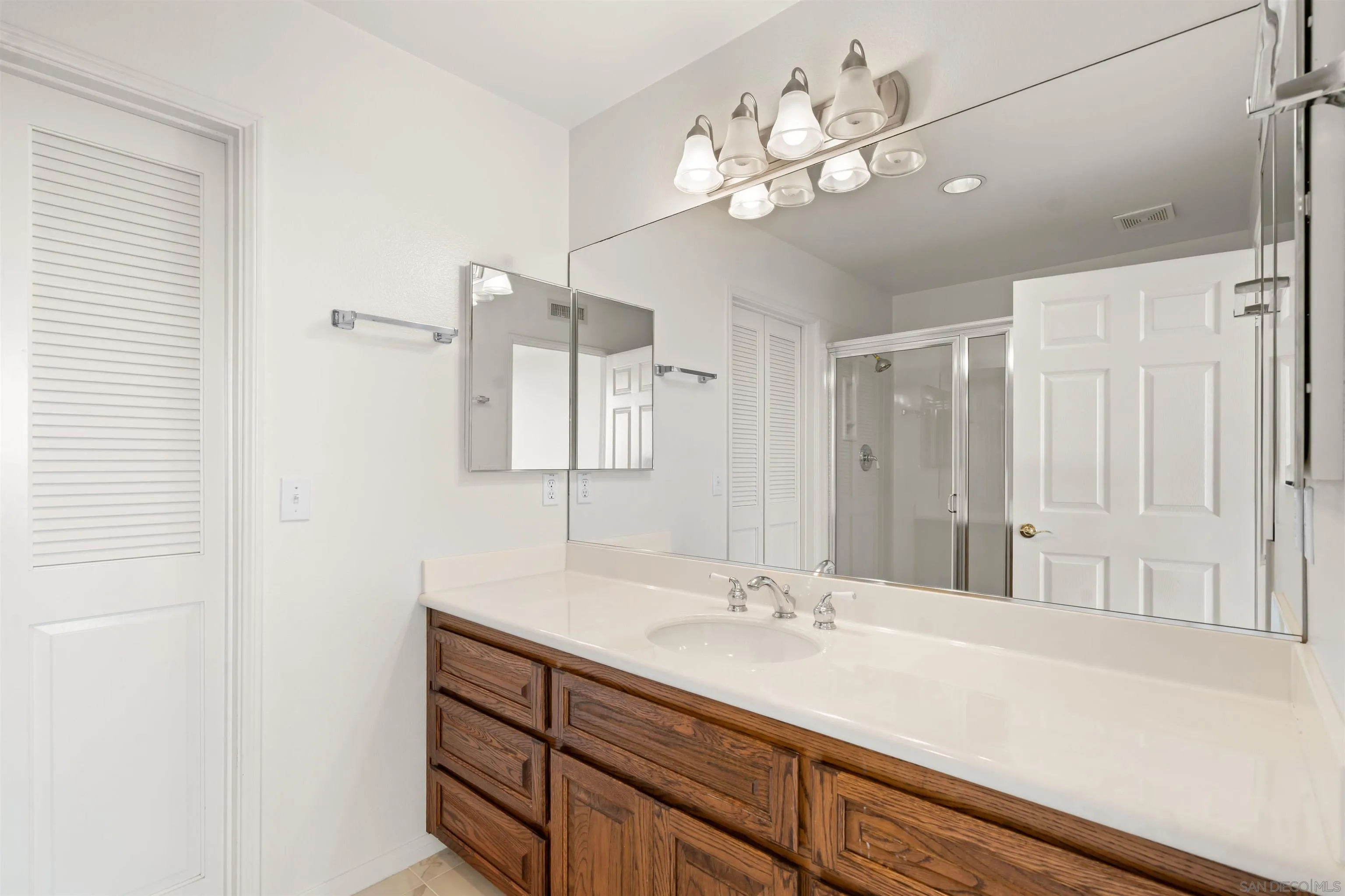 13286 Ocean Vista Road San Diego, CA 92130 - Photo 50 of 66 a bathroom with a sink a vanity a lamp and a mirror