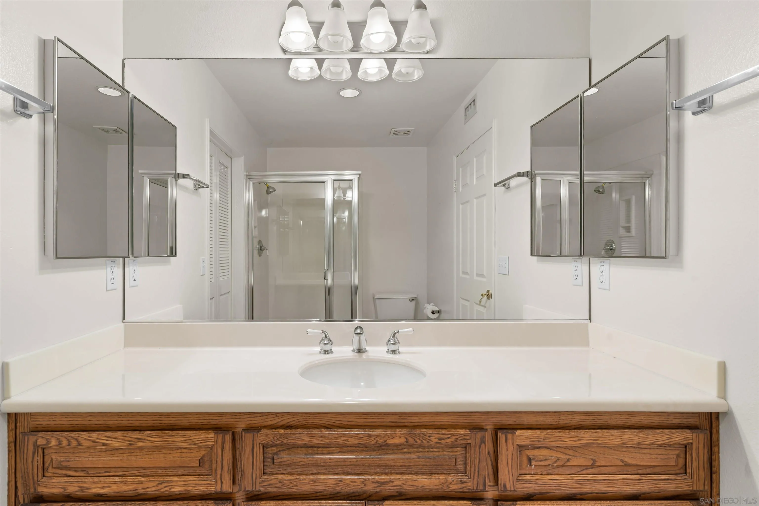 13286 Ocean Vista Road San Diego, CA 92130 - Photo 51 of 66 a bathroom with a sink a large mirror and vanity