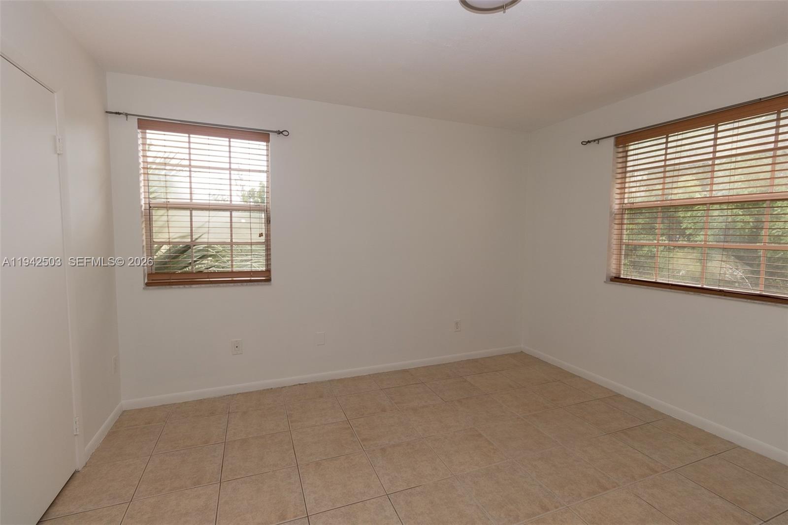 18328 Northwest 68th Avenue, Unit P Hialeah, FL 33015 - Photo 11 of 26 an empty room with a window