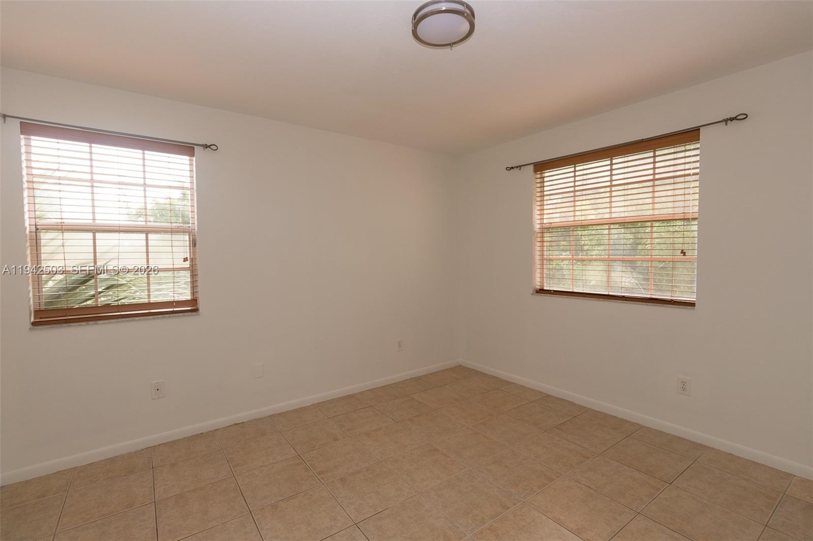 18328 Northwest 68th Avenue, Unit P Hialeah, FL 33015 - Photo 12 of 26 an empty room with windows