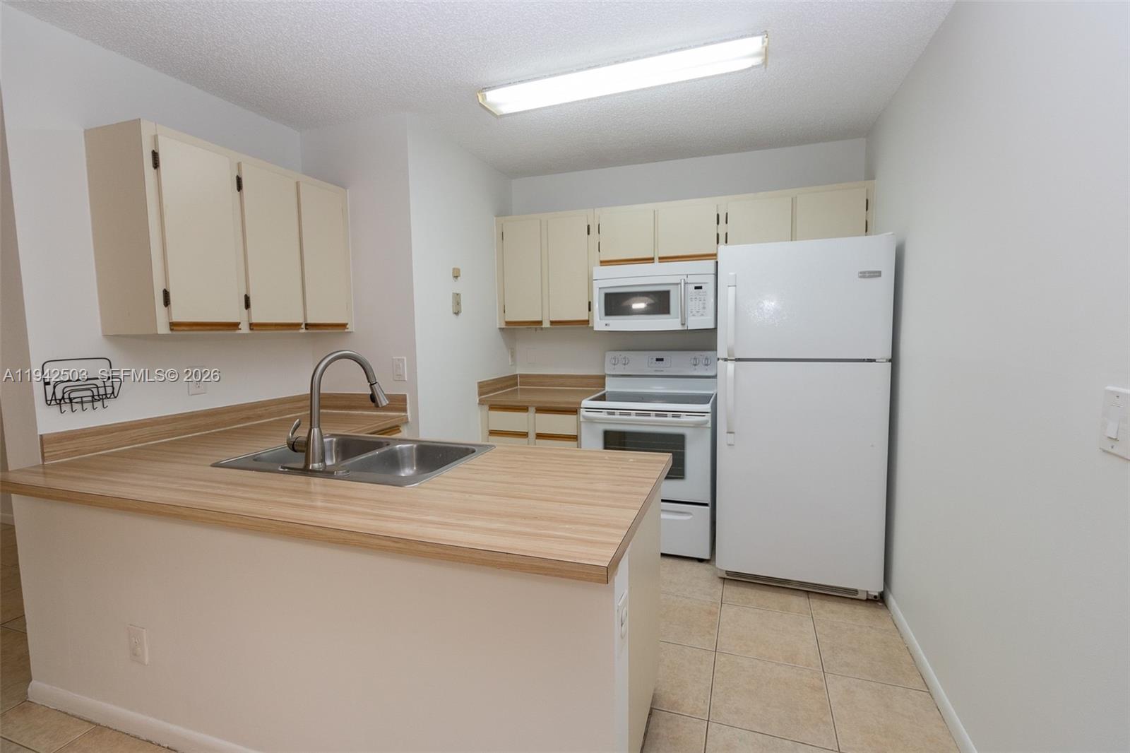18328 Northwest 68th Avenue, Unit P Hialeah, FL 33015 - Photo 2 of 26 a kitchen with appliances a sink and a counter top space