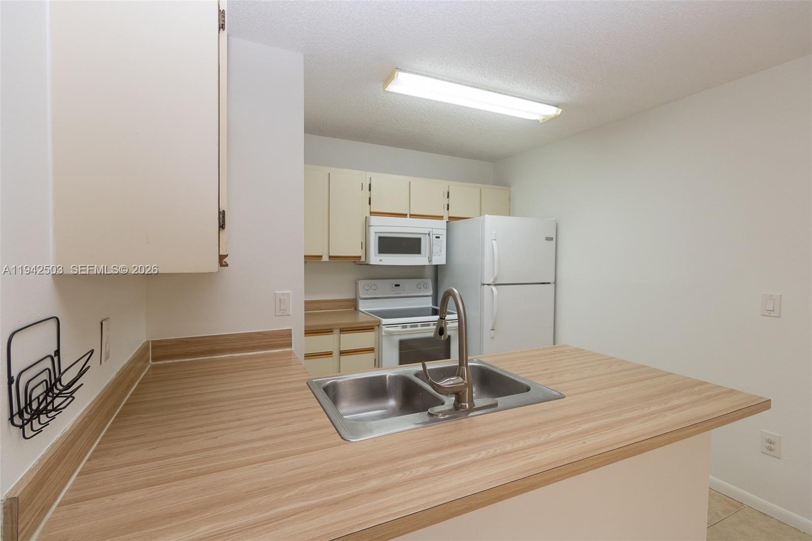 18328 Northwest 68th Avenue, Unit P Hialeah, FL 33015 - Photo 3 of 26 a kitchen with a sink cabinets stainless steel appliances and a counter top space