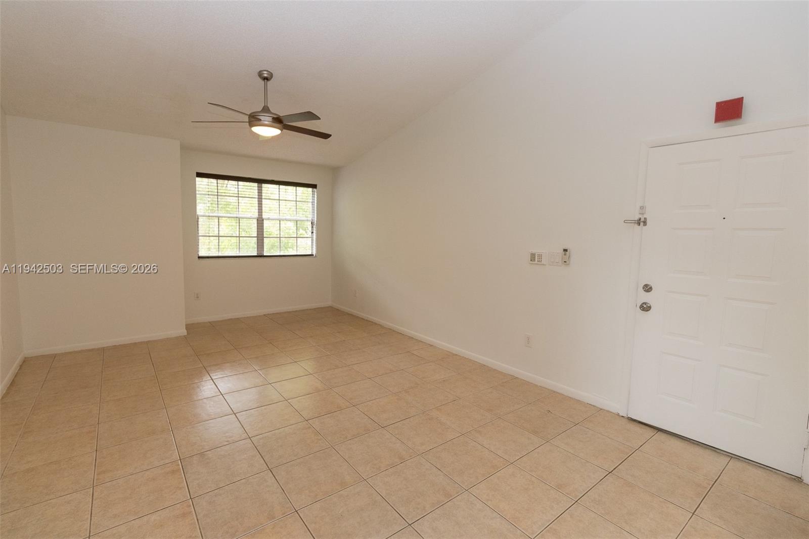 18328 Northwest 68th Avenue, Unit P Hialeah, FL 33015 - Photo 9 of 26 an empty room with windows and chandelier fan