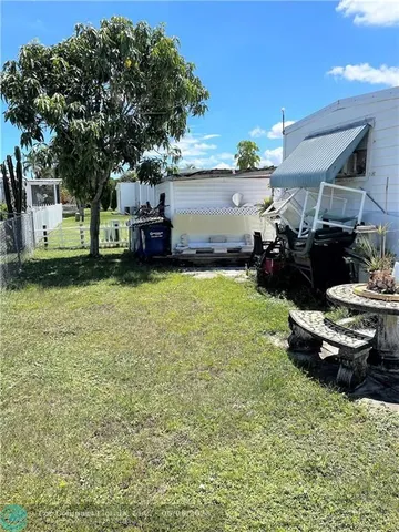 a view of a backyard with plants and a fountain