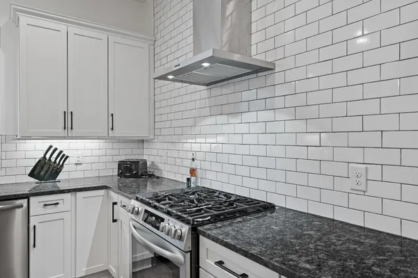 a kitchen with granite countertop a sink and a stove