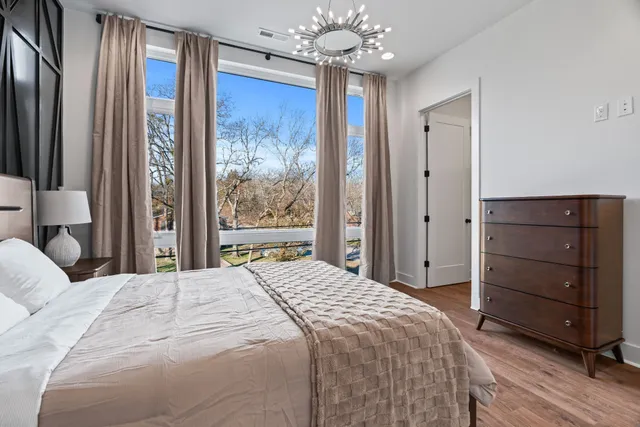 a bedroom with a large bed and a chandelier