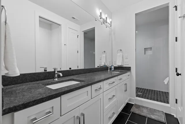 a bathroom with double vanity and a mirror