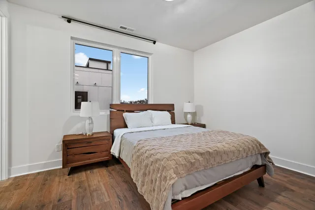 a bed sitting in a bedroom next to a bathroom mirror