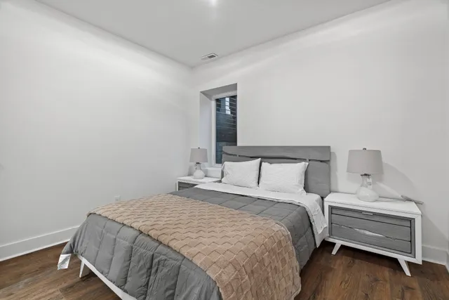 a bedroom with a bed and wooden floor