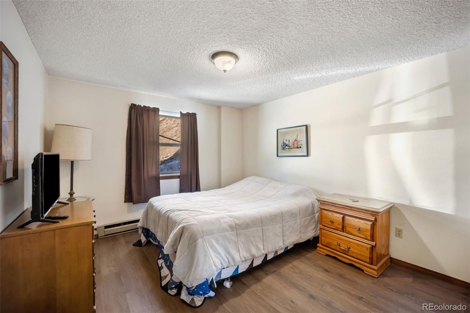 415 Bishop Road Bailey, CO 80421 - Photo 7 of 39 a bedroom with a bed and wooden floor